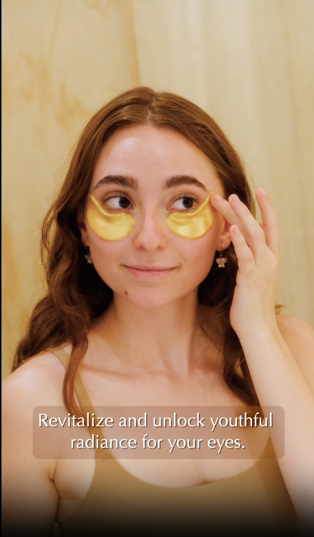 a beautiful redhead girl in a natural ambiance bathroom wearing gold eye masks under the eyes