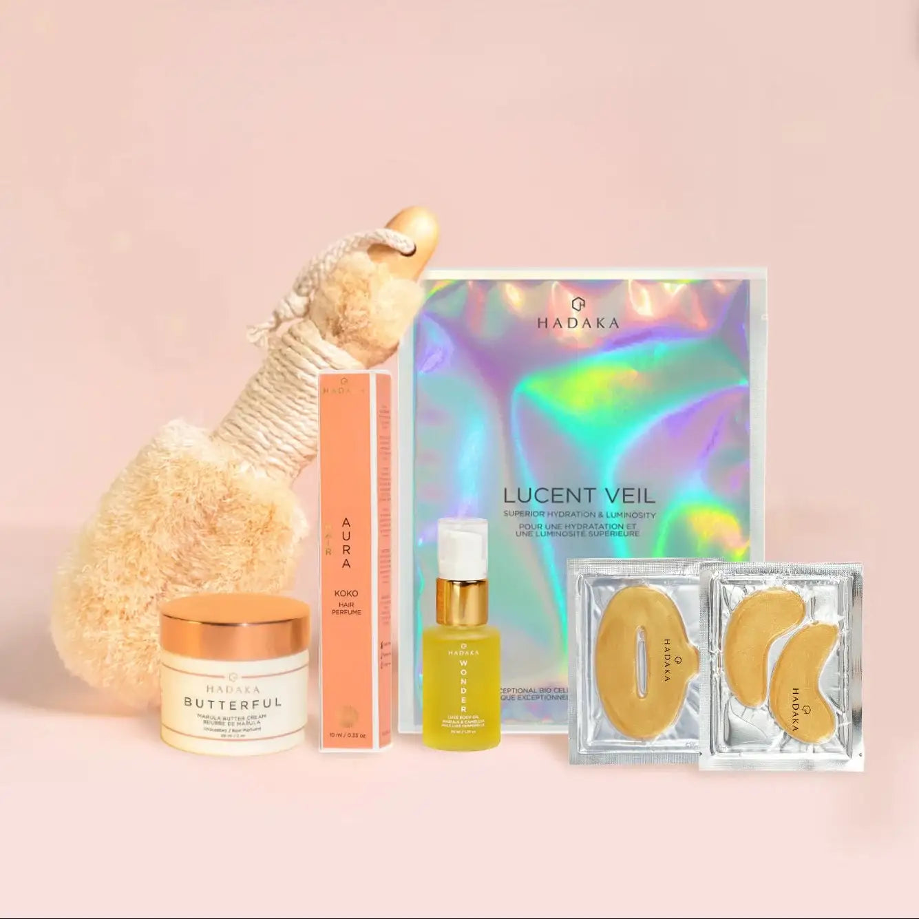 Skincare holiday kit with hydrating face mask, serum, cream, eye masks, plush toy on pink